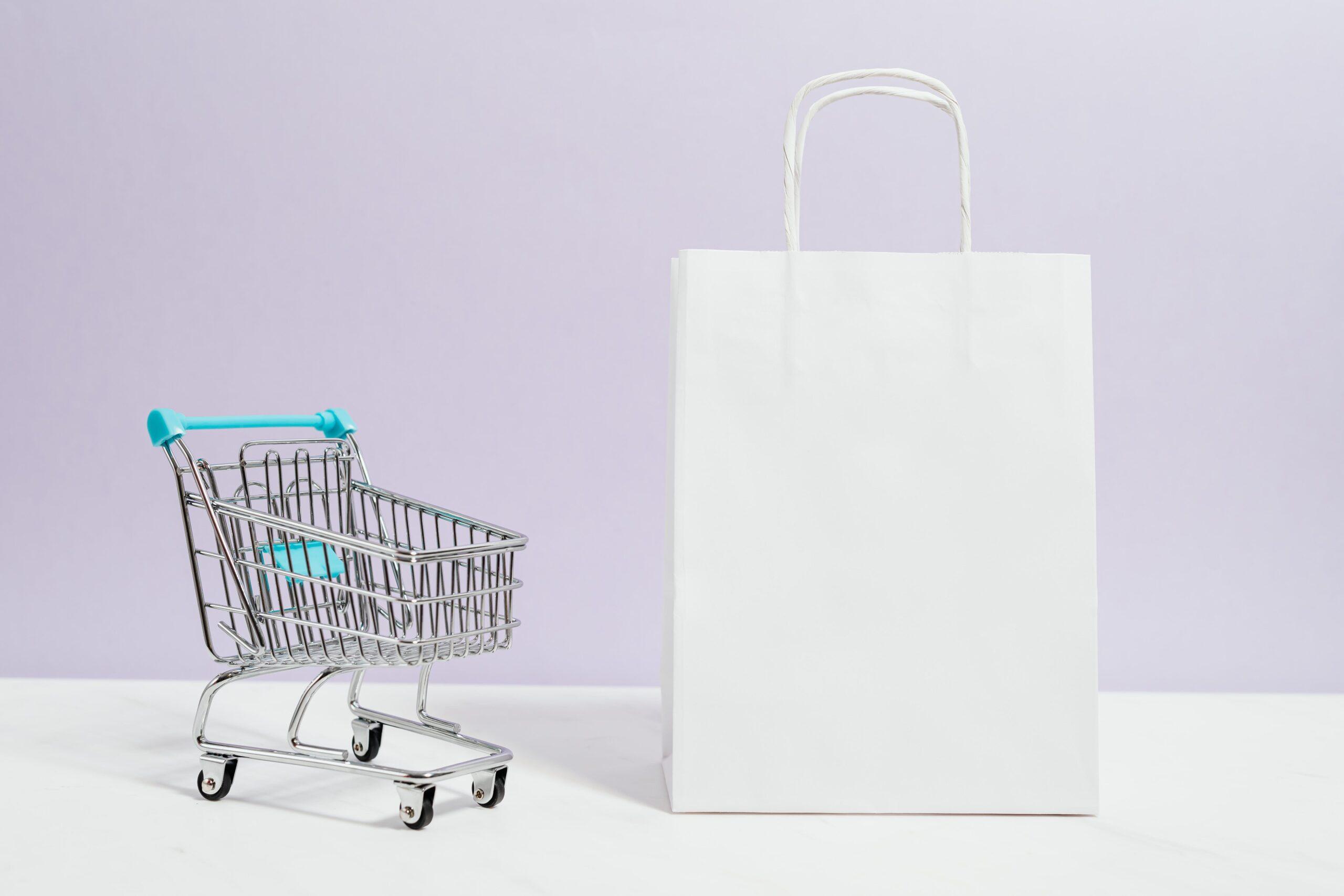 Método AIDA en ventas: mini carrito de supermercado junto a una bolsa de compra
